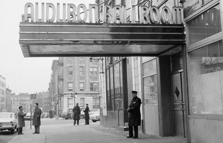 FILE – New York police officers stand outside the Audubon Ballroom on 166th Street at Broadway in the Harlem section of Manhattan, where black Muslim leader Malcolm X was assassinated as he addressed a rally on Feb. 21, 1965, in New York. Two of the three men convicted in the assassination of Malcolm X are set to be cleared Thursday, Nov. 18, 2021, after insisting on their innocence since the 1965 killing of one of the United States’ most formidable fighters for civil rights, Manhattan’s top prosecutor said Wednesday, Nov. 17, 2021. (AP Photo) NYJJ101 NYJJ101