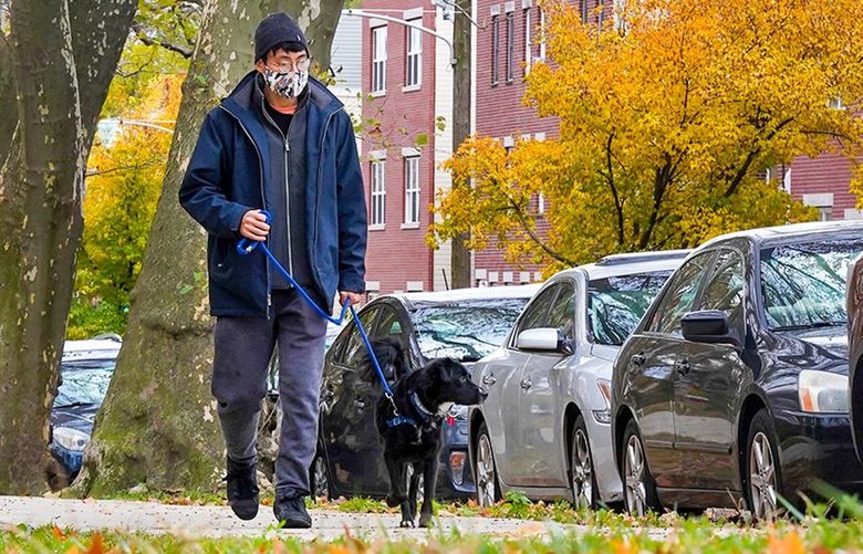 Christopher Hsieh walks his dog Petunia at Clark Park in Philadelphia. Sidewalks and proximity to parks are two amenities that pet owners seek when they decide where to live. (Thomas Hengge / The Philadelphia Inquirer / TNS) 32569288W