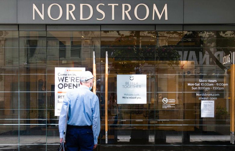A pedestrian reads signs on a door of the Nordstrom flagship store in Seattle, Washington, U.S., on Tuesday, June 23, 2020. Seattle and King County moved into Phase 2 of the state’s pandemic reopening plan on Friday despite a rising number of confirmed Covid-19 cases. Photographer: Chona Kasinger/Bloomberg 775526371