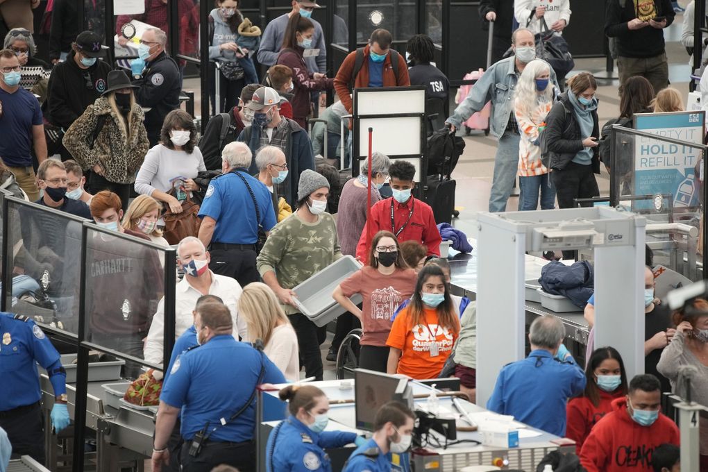 Travelers queue up at the south security checkpoint on Tuesday, Nov. 23, 2021, at Denver International Airport in Denver. Millions of Americans, many of them vaccinated, will return to the Thanksgiving table this week for the first time in two years. But COVID-19 is accelerating at a disturbing pace. It’s not time to claim “mission accomplished,” one official warns. (David Zalubowski / The Associated Press)