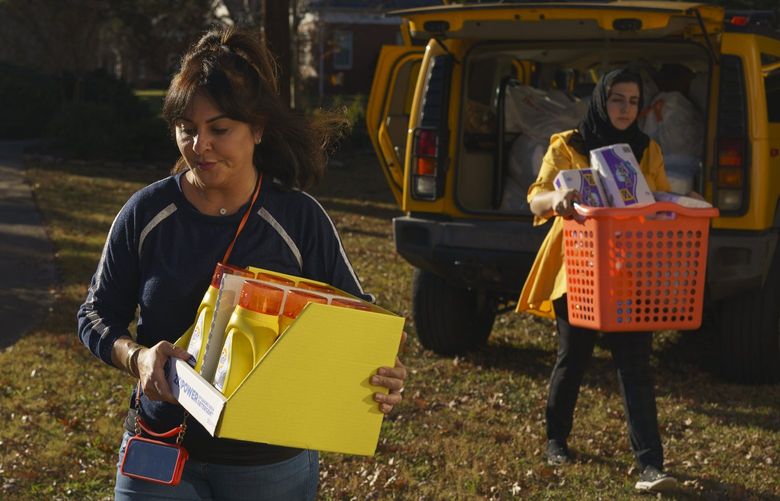 Maryam Aytac, a community member and volunteer coordinator, left, and Shaista Amani, economic empowerment coordinator for the Refugee Women’s Network, help unload donated goods for newly arrived Afghan refugee families at Amani’s office in Decatur, Ga. MUST CREDIT: Photo by Elijah Nouvelage for The Washington Post.