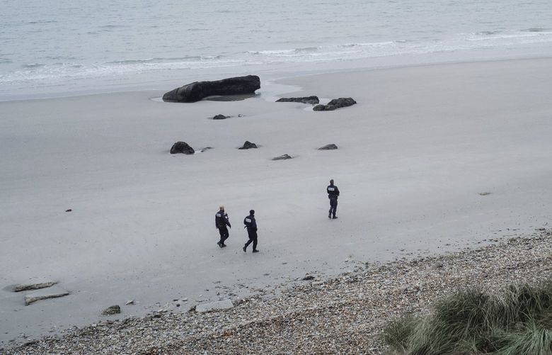 French police officers patrol on the beach in the searcher migrants in Wimereux, northern France, Wednesday, Nov.17, 2021. Several migrants died and others were injured Wednesday Nov.24, 2021 when their boat capsized off Calais in the English Channel as they tried to cross from France to Britain, authorities said. British and French authorities were searching the area using helicopters and coast guard vessels, according to the French maritime agency for the region. (AP Photo/Louis Witter, File) PAR119 PAR119