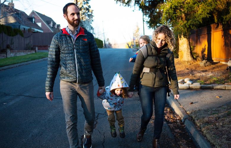 Sarah and Keith James take a walk with their two boys Elias, center, 3, and Lincoln, 1, in their neighborhood in Yakima, Wash. Tuesday, Nov. 23, 2021. Keith and Sarah were the first couple in UW Medicineâ€™s transplant program where Sarah gave a lobe of liver to her husband Keith, who had been ill for years making a transplant critical.