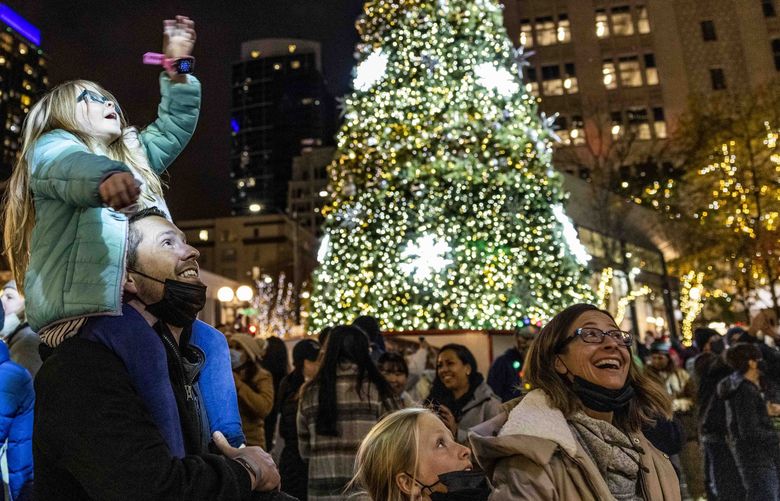 Brian Rigmaiden holds his daughter Bella, 6, as she waves goodbye to Santa during the Westlake Center lighting in Seattle on Black Friday, Nov. 26, 2021.