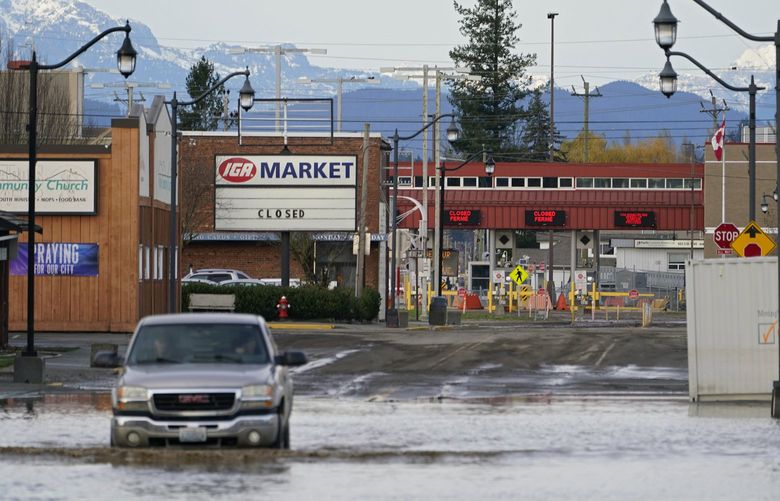 Floodwater covers a roadway near a closed crossing to Canada, Wednesday, Nov. 17, 2021, in Sumas, Wash. An atmospheric riverâ€”a huge plume of moisture extending over the Pacific and into Washington and Oregonâ€”caused heavy rainfall in recent days, bringing major flooding in the area. (AP Photo/Elaine Thompson) NVJL229 NVJL229