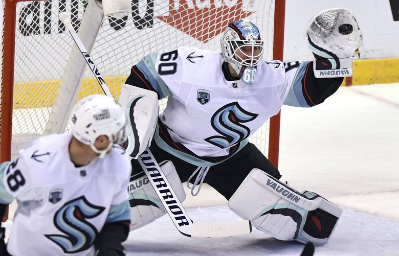 Seattle Kraken goaltender Chris Driedger (60) makes a glove save against the Florida Panthers during the first period of an NHL hockey game Saturday, Nov. 27, 2021, in Sunrise, Fla. (AP Photo/Jim Rassol) FLJS105 FLJS105