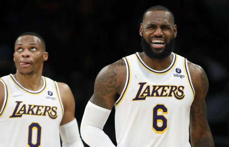 Los Angeles Lakers forward LeBron James, right, grimaces after making a basket against the Detroit Pistons, with guard Russell Westbrook, left, looking up at a video replay during the second half of an NBA basketball game Sunday, Nov. 28, 2021, in Los Angeles. (AP Photo/Alex Gallardo) LAS141 LAS141
