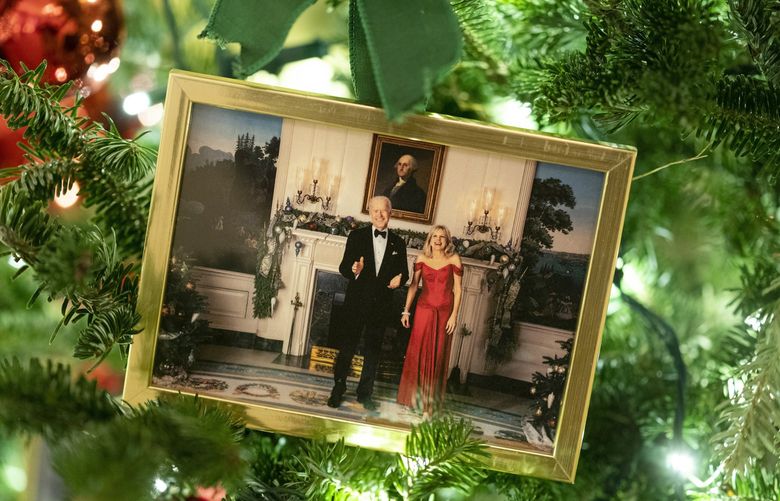 A photo of President Joe Biden and first lady Jill Biden sits in a Christmas tree in the State Dining Room of the White House during a press preview of the White House holiday decorations, Monday, Nov. 29, 2021, in Washington. (AP Photo/Evan Vucci) DCEV143 DCEV143