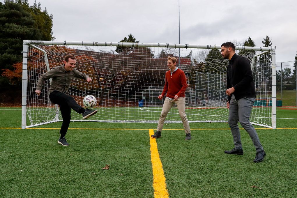 Ballard FC owners, left to right, Sam Zisette, Chris Kaimmer and Lamar Neagle juggle the ball during a visit to the Loyal Heights Playground on Friday, November 19, 2021 in Seattle.  (Jennifer Buchanan / The Seattle Times)
