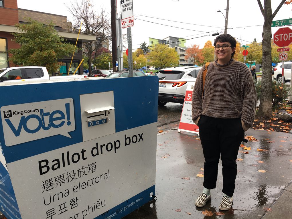 Remy Coronado, 26, of Phinney Ridge, dropped off her ballot at the drop box outside the Ballard library. (Lewis Kamb / The Seattle Times)