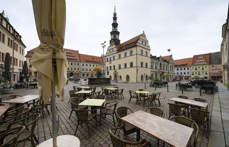 The market square with the town hall of the city center of Pirna, Saxony in East Germany is deserted on Monday, Nov. 8, 2021. Within 24 hours, 2423 new Corona infections were reported to the RKI from Saxony and no further deaths. In the district of Saechsische Schweiz-Osterzgebirge, the seven-day incidence reached a value of 924.3 today. (Robert Michael/dpa via AP) DMME113 DMME113