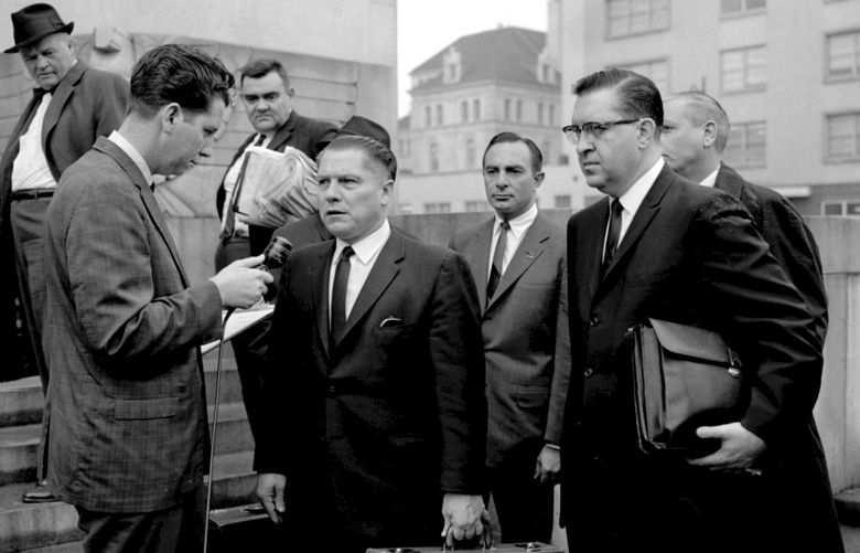 In this 1964 photo, a reporter questions Teamsters President Jimmy Hoffa outside the federal courthouse in Chattanooga, Tenn., during Hoffa’s trial that ended in a jury tampering conviction. The decades-long odyssey to find the body of former Teamsters boss Jimmy Hoffa apparently has turned to a former New Jersey landfill below an elevated highway. The FBI obtained a search warrant to “conduct a site survey underneath the Pulaski Skyway,” Mara Schneider, a spokeswoman for the Detroit field office, said in a written statement Friday, Nov. 19, 2021. (Chattanooga Times Free Press via AP, File) TNCHA501 TNCHA501