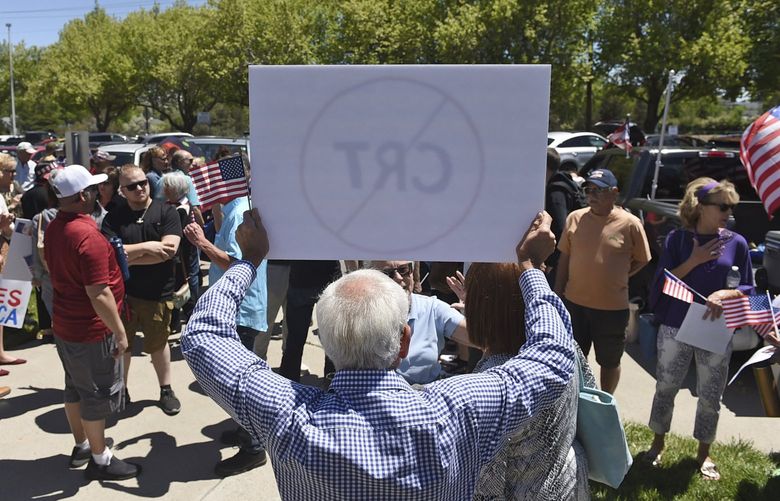 FILE – A man holds up a sign against Critical Race Theory during a protest outside a Washoe County School District board meeting on May 25, 2021, in Reno, Nev. Critical race theory has become a lightning rod for Republicans and an issue in some Election Day races around the country. (Andy Barron/The Reno Gazette-Journal via AP, File) NVREN281 NVREN281
