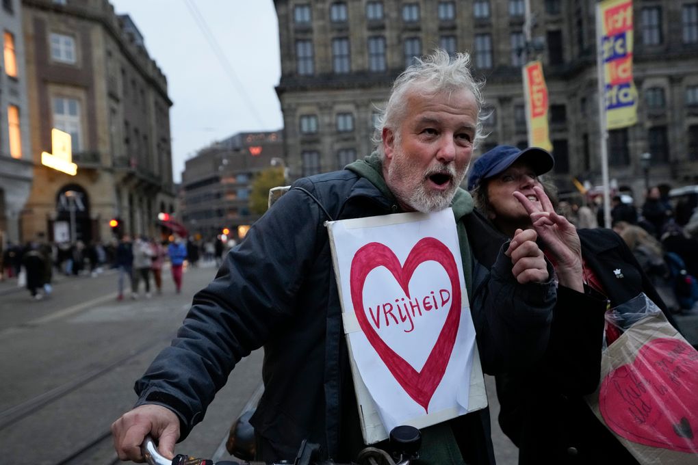 A protestor wears a sign reading “Freedom” during a demonstration against COVID-19 restrictions in Amsterdam, Netherlands, on Saturday, Nov. 20, 2021. (AP Photo/Peter Dejong)