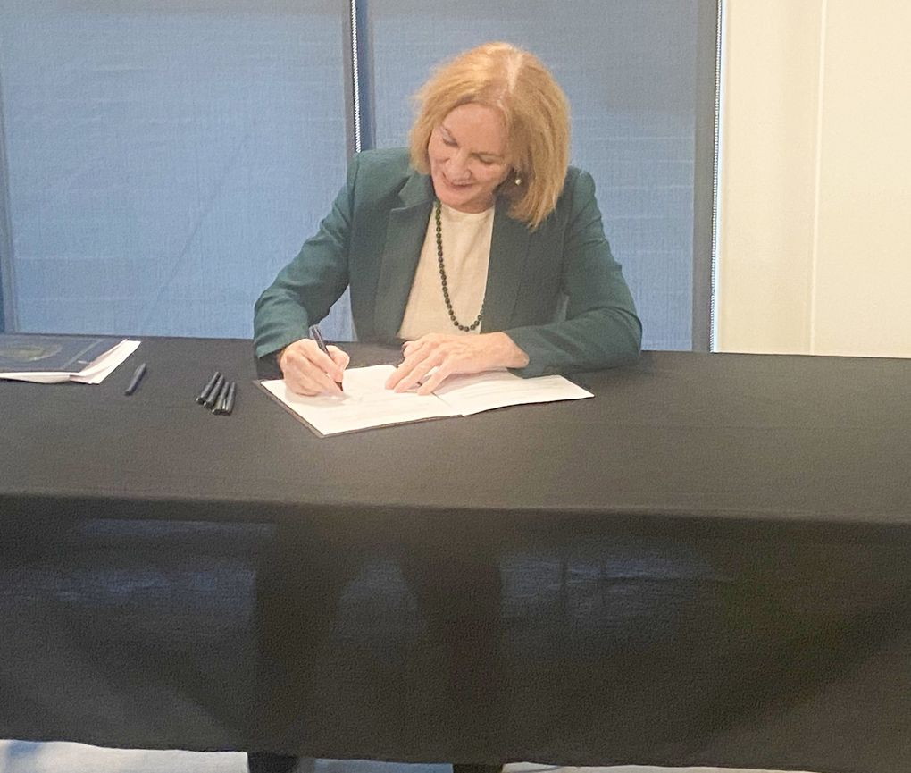 Mayor Jenny Durkan signs the city of Seattle’s $7.1 billion 2022 budget into law at the Kristin Benson Place housing development on Thursday. Durkan signed her final budget in office, despite disagreement with the City Council over public safety funding. (Sarah Grace Taylor / The Seattle Times)