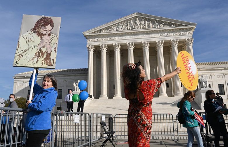 Barbara DuBrul of Long Island, N.Y., left, stands in the designated area for antiabortion supporters as an abortion rights supporter, who did not want to give her name, dances nearby outside the Supreme Court. MUST CREDIT: Washington Post photo by Matt McClain