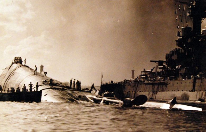 The capsized USS Oklahoma and the USS Maryland are shown after the Dec. 7, 1941, attack. MUST CREDIT: National Archives