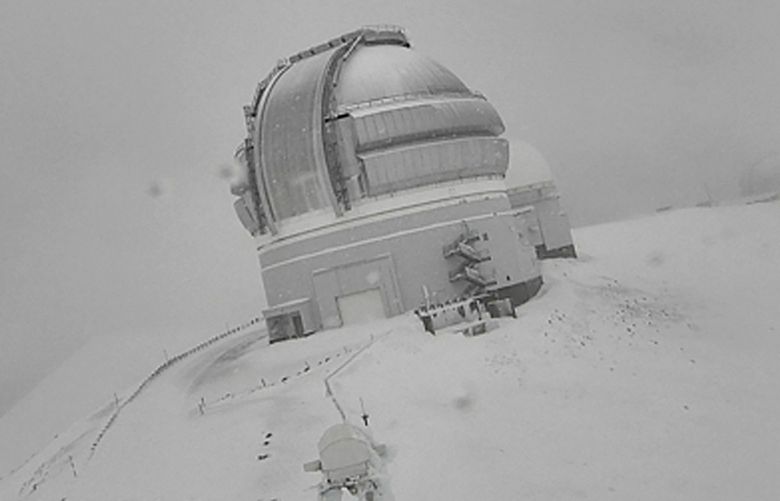 In this webcam image provided by the Canada-France-Hawai »i Telescope, snow is seen atop the summit of Mauna Kea in Hawaii on Monday, Dec. 6, 2021. A strong storm packing high winds and extremely heavy rain flooded roads and downed power lines and tree branches across Hawaii. (Canada-France-Hawai »i Telescope via AP) FX108 FX108