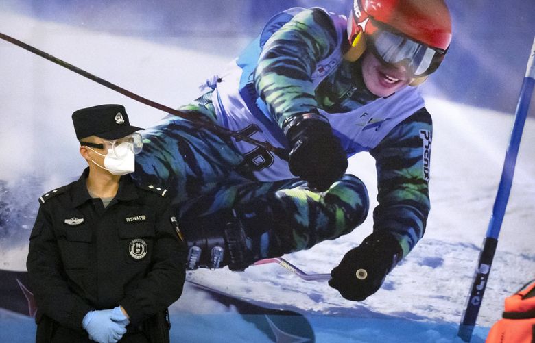 FILE – A police officer wearing a face mask and goggles to protect against COVID-19, stands near a poster of a skier on the wall at a train station in Zhangjiakou in northern China’s Hebei Province, Friday, Nov. 26, 2021. China is threatening to take “firm countermeasures” if the U.S. proceeds with a diplomatic boycott of February’s Beijing Winter Olympic Games. Foreign Ministry spokesperson Zhao Lijian on Monday accused U.S. politicians of grandstanding over the issue of not sending dignitaries to attend the events that China hopes will showcase its economic development. (AP Photo/Mark Schiefelbein, File) BKWS303 BKWS303 (Mark Schiefelbein / The Associated Press)