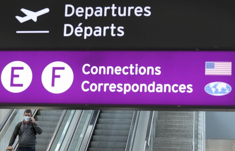 People travel at Pearson International Airport during the COVID-19 pandemic in Toronto, Friday, Dec. 3, 2021. New travel testing and restrictions have been put in place due to the omicron variant. (Nathan Denette /The Canadian Press via AP) NSD110 NSD110