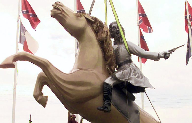 FILE â€” A statue of Gen. Nathan Bedford Forrest is put up along Interstate 65 in Nashville, Tenn., in December 1998. The controversial statue of Forrest, a Confederate General and the first Grand Wizard of the Ku Klux Klan, was removed Tuesday, Dec. 7, 2021, one year after Bill Dorris, the owner of the statue and the property where it stood, passed away. (AP Photo/Mark Humphrey, File) TNMH102 TNMH102