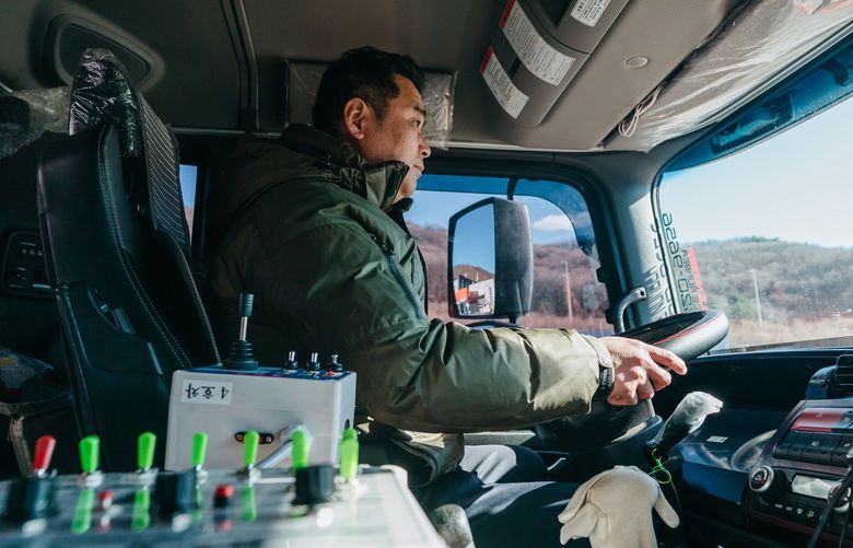 Kim Jung-suk sits in his diesel dump truck in Seoul, South Korea on Dec. 3, 2021. The truck uses urea, which goes into an industrial elixir that reduces trucks’ greenhouse gas emissions and that South Korea doesn’t allow diesel engines to start without. (Jun Michael Park/The New York Times) XNYT33 XNYT33