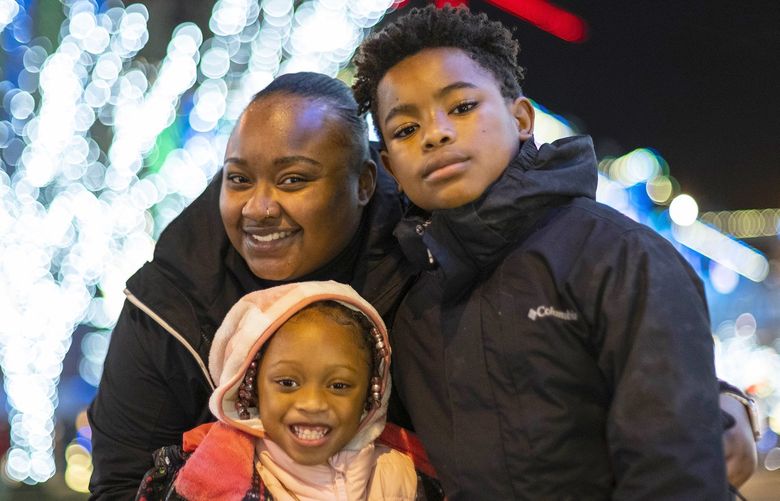 Denisha Dunston and her children – John, 10; and Azaria, 5 – enjoy the sights and sounds of Snowflake Lane in Bellevue Thursday, December 2, 2021. 218895
