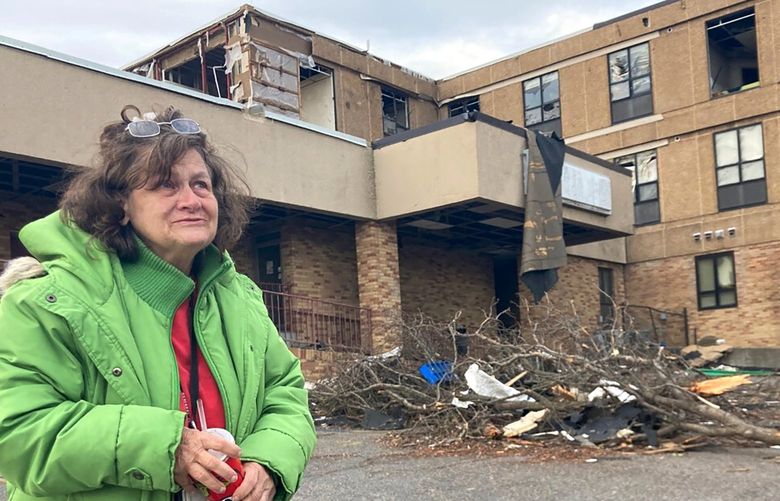 Judy Burton stands outside her apartment building, which was severely damaged in Friday’s tornados, in Mayfield, Ky., Sunday, Dec. 12, 2021. Burton and her dog barely escaped as one of the most devastating tornados in American history tore apart her town of 10,000 people.(AP Photo/Claire Galofaro) RPCG102 RPCG102