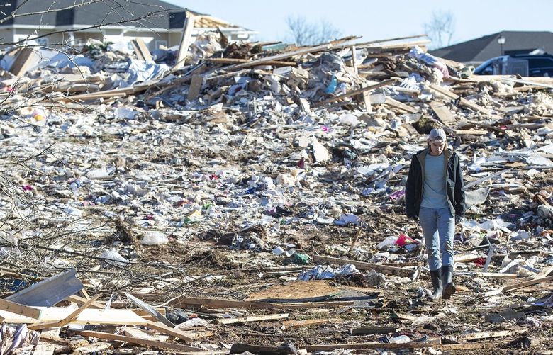 A man walks through the wrecked remains of houses in a neighborhood off Russellville Road after a tornado swept through Friday night in Bowling Green, Ky., Sunday, December 12, 2021. (Silas Walker/Lexington Herald-Leader/TNS) 34679546W 34679546W