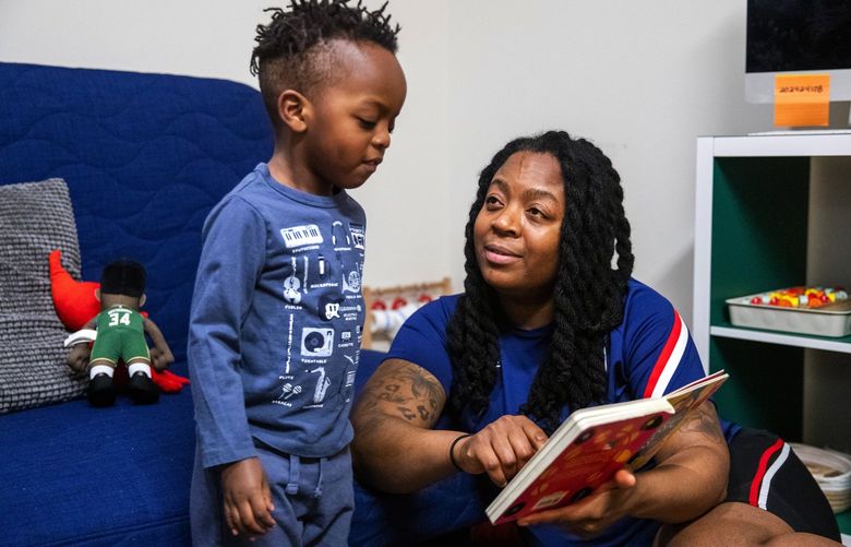 China Perkins reads a book to her son Kingston in their Seattle apartment on Wednesday, Dec. 8, 2021.

Their one bedroom apartment is full of children’s books and musical instruments for Kingston. Perkins also works in early childhood education in Bellevue.

Wellspring Family Services was able to help get Perkins  into affordable housing. When they moved in, Wellspring furnished the apartment with everything they needed.