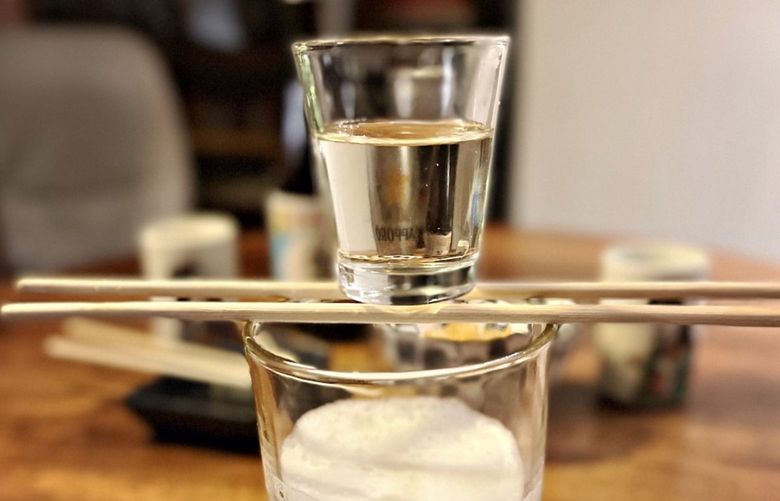 A sake bomb can be a spectacular show. A small glass of sake is balanced on chopsticks before it plunges into the beer glass below with explosive results. Credit: Tantri Wija