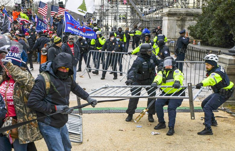 FILE — Rioters at the Capitol wrestle over barriers with police, in Washington, Jan. 6, 2021. The Fox News hosts Sean Hannity and Laura Ingraham vociferously defended themselves for sending text messages on Jan. 6 that urged Mark Meadows, the last White House chief of staff under Donald Trump, to persuade the then-president to take action to stop the Capitol attack. (Kenny Holston/The New York Times) XNYT162