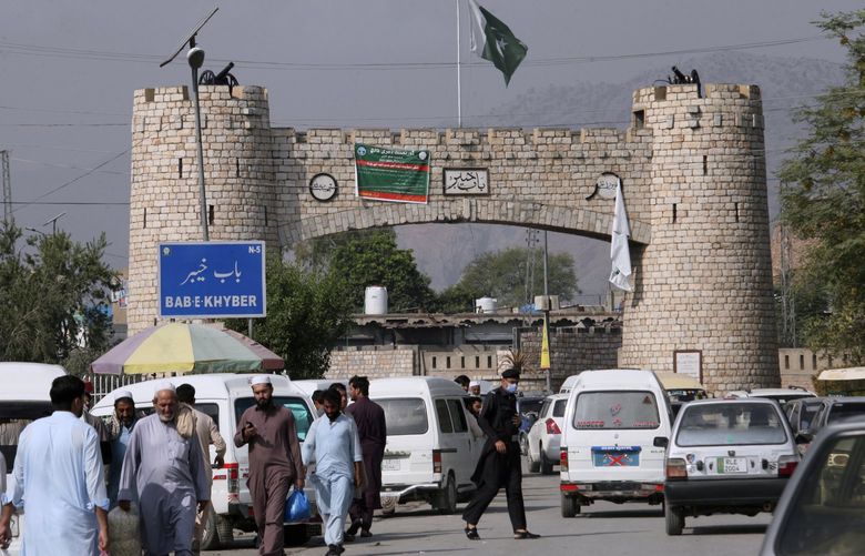 People walk while vehicle move through historical Khyber Pass in Jamrud, the main town of Pakistan’s Khyber district bordering Afghanistan, Monday, Oct. 11, 2021.  Wahab, the youngest son of four from a wealthy Pakistani family was rescued by his uncle, from a Taliban training camp on Pakistanâ€™s border with Afghanistan earlier this year. His uncle blamed his slide to radicalization on the neighborhood teens Wahab socialized with in their northwest Pakistan hometown, plus video games and Internet sites his friends introduced to him.  (AP Photo/Muhammad Sajjad)