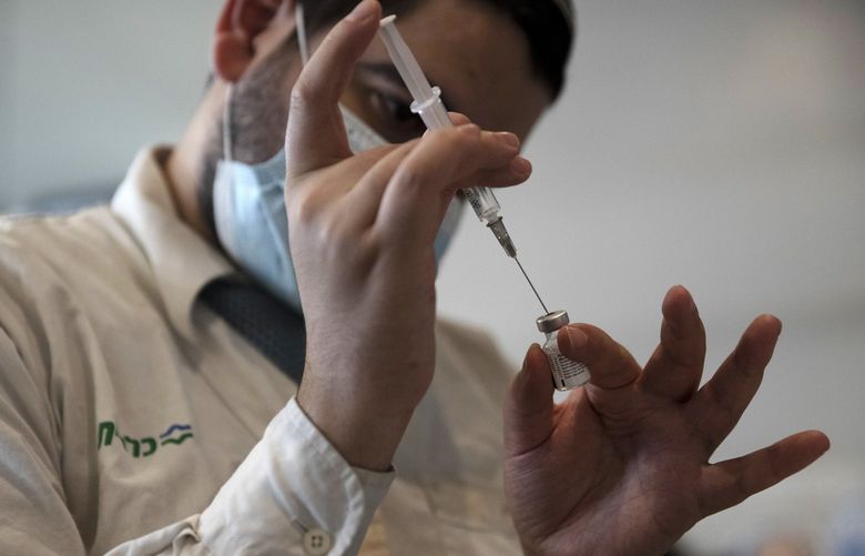 A medical worker prepares a vial of the Pfizer coronavirus vaccine at Clalit Health Service’s center in the Cinema City complex in Jerusalem, Wednesday, Sept. 22, 2021. Israel is pressing ahead with its aggressive campaign of offering coronavirus boosters to almost anyone over 12 and says its approach was further vindicated by a U.S. decision to give the shots to older patients or those at higher risk. (AP Photo/Maya Alleruzzo)