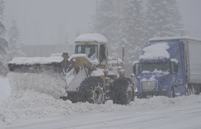 Heavy equipment is used to clear snow from a road near the Summit at Snoqualmie Ski Area, Thursday, Dec. 9, 2021, near Snoqualmie Pass in Washington state. Heavy snowfall Thursday slowed traffic and led to periodic closures of Interstate Highway 90. (AP Photo/Ted S. Warren) WATW102 WATW102