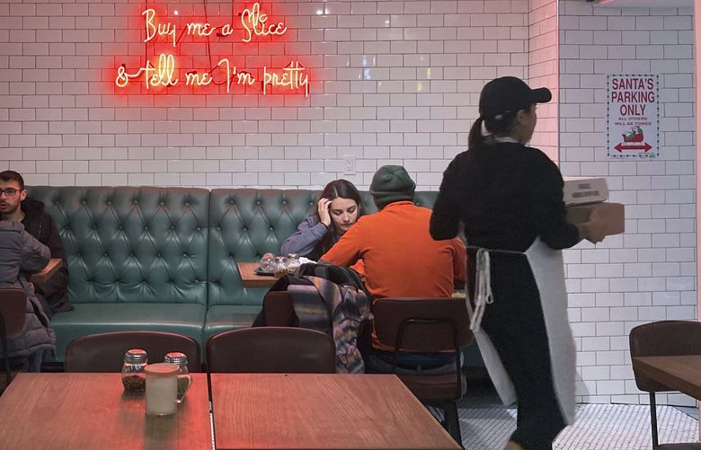 People eat inside the Siena Pizza restaurant in New York City on Thursday, December 9, 2021. (AP Photo/Ted Shaffrey) RPTS101 RPTS101