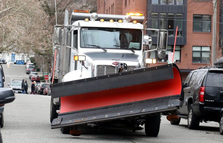 SDOT snow plow driver James Doyle maneuvers his truck Westbound on John Street, West of Seattle Center, on a dry run, Friday, December 24, 2021. He was driving one of his routes before the predicted snow arrives. 219181