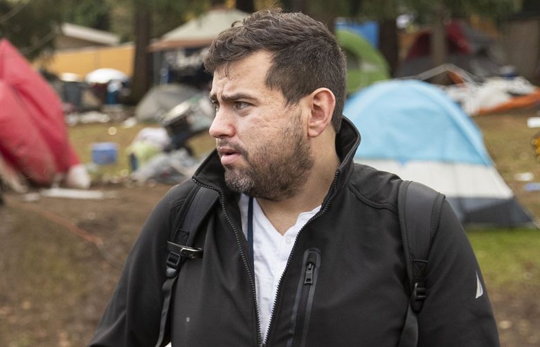 Mike Mathias, former executive director of volunteer-run organization Anything Helps, collects information from people living at Bitter Lake homeless encampment so they can get on a list for temporary housing on Monday, Nov. 29, 2021