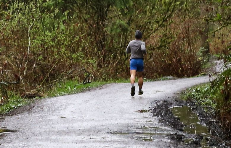 A jogger runs through Ravenna Park during the coronavirus outbreak on March 31, 2020, in Seattle.