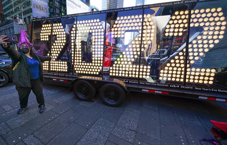 Teresa Hui poses for a selfie in front of a 2022 sign displayed in Times Square, New York, Monday, Dec. 20, 2021. Crowds will once again fill New York’s Times Square this New Year’s Eve, with proof of COVID-19 vaccination required for revelers who want to watch the ball drop in person, Mayor Bill de Blasio announced last week. (AP Photo/Seth Wenig) NYSW104 NYSW104