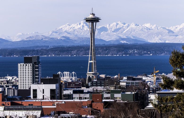 The Space Needle stands in front of the Olympic Mountains on Wednesday, Dec. 29, 2021. The mountains show off their snowy peaks after a few days of cold weather and snow in Western Washington. LO