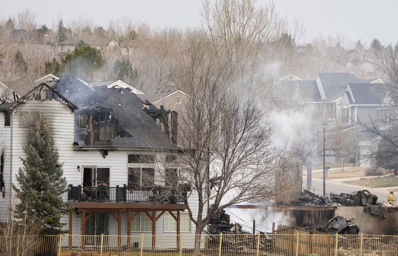 The remains of homes smolder on Friday, Dec. 31, 2021, after wildfires ripped through a development in Superior, Colo. (AP Photo/David Zalubowski) CODZ136 CODZ136