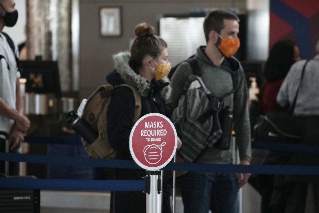The sign warns travelers that when boarding due to COVID-19 restrictions, travelers will need a mask at the Delta Airlines check-in counter last week at Denver International Airport in Denver.  (David Zalubovsky / Associated Press)