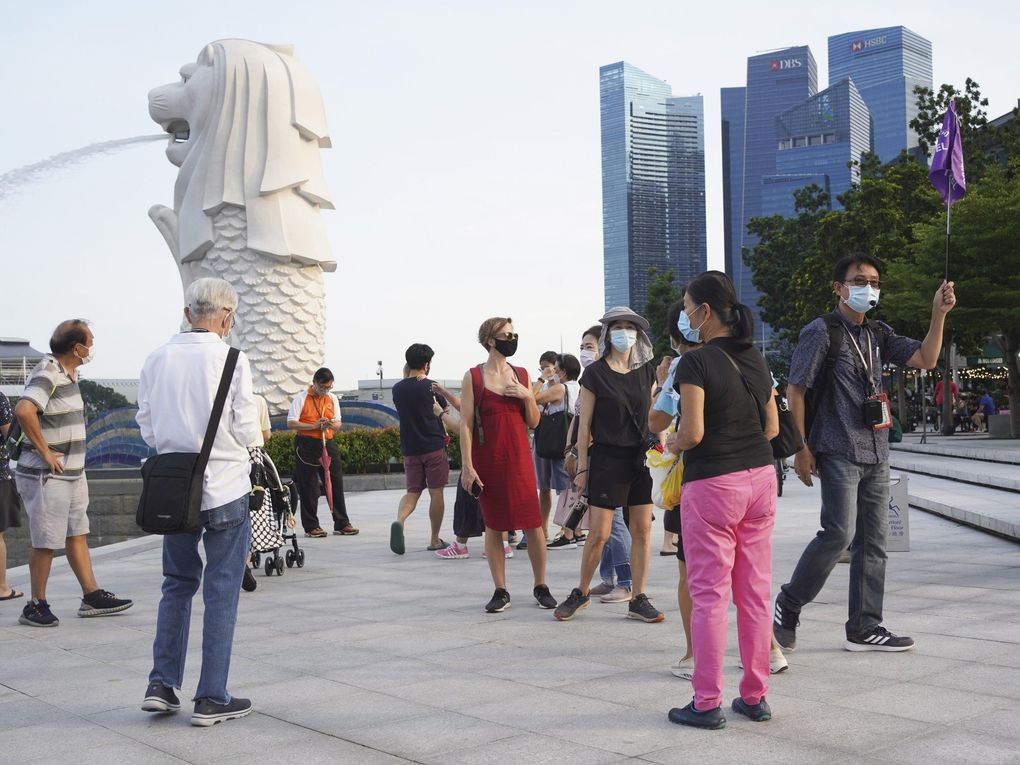 (FILE) Tourists walk in the Marina Bay area of Singapore, on Saturday, Sept. 25, 2021. Singapore’s health ministry said Thursday that preliminary tests detected the new omicron variant of the coronavirus in two passengers who arrived on a plane from Johannesburg, the country’s first suspected cases. (Bloomberg)
