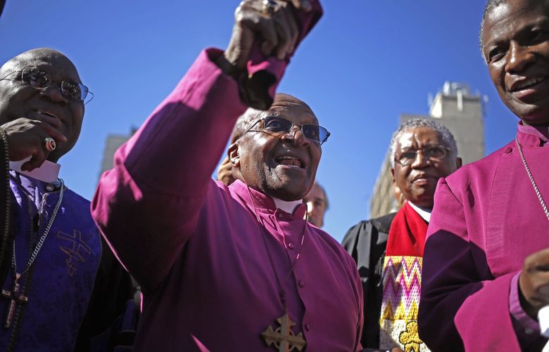 In this photo taken on Saturday, April 19, 2014, South African Archbishop Desmond Tutu, center, speaks after he marched in a rally with other religious leader under the banner of  ‘A Call to Witness’ to parliament in the city of Cape Town, South Africa.“How can you describe falling in love?” That is how retired archbishop Desmond Tutu this week recalled the joy of voting in South Africa’s first all-race elections on April 27, 1994, an exultant moment when a population torn by racial conflict stepped out of the shadow of the white minority rule known as apartheid. (AP Photo/Schalk van Zuydam) ASVZ118