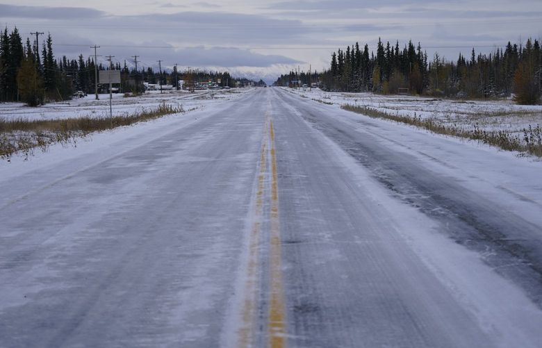 Ice and snow covers the Alaska Highway Wednesday, Sept. 22, 2021, in Tok, Alaska. The state is experiencing one of the sharpest rises in COVID-19 cases in the country, coupled with a limited statewide healthcare system that is almost entirely reliant on Anchorage hospitals. (AP Photo/Rick Bowmer)