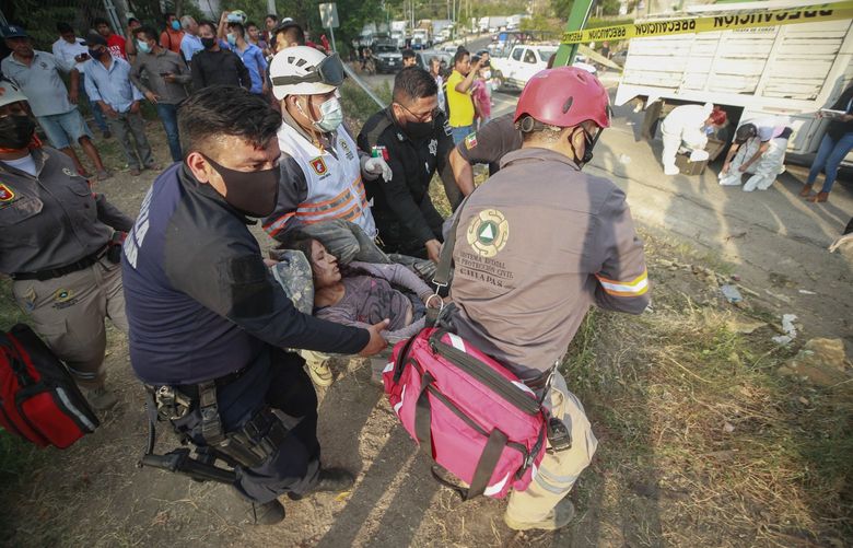 An injured migrant woman is moved by rescue personnel from the site of an accident near Tuxtla Gutierrez, Chiapas state, Mexico, Dec. 9, 2021. Mexican authorities say at least 49 people were killed and dozens more injured when the truck carrying the migrants rolled over on the highway in southern Mexico. (AP Photo) MXEV106 MXEV106