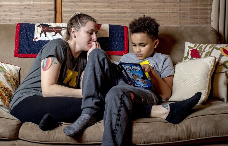 Caitlin Reynolds and her son, L.J., at home in Royal Oak, Mich, on Nov. 30, 2021.  Because of school cancellations last academic year, Reynolds, who works at a University of Michigan research lab, has already run out of paid time off.   (Nic Antaya/The New York Times)