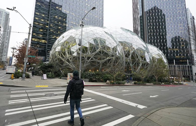 A pedestrian walks near the Amazon Spheres on the company’s corporate campus in downtown Seattle, Tuesday, Dec. 7, 2021. Amazon Web Services suffered a major outage Tuesday, the company said, disrupting access to many popular sites. The company provides cloud computing services to many governments, universities and companies, including The Associated Press. (AP Photo/Ted S. Warren) WATW105 WATW105