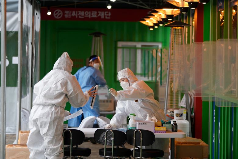 2021 年 12 月 29 日星期三，身穿防护服的医务人员准备在韩国首尔的冠状病毒临时筛查诊所采集样本。（美联社照片 / Lee Jin-man）
